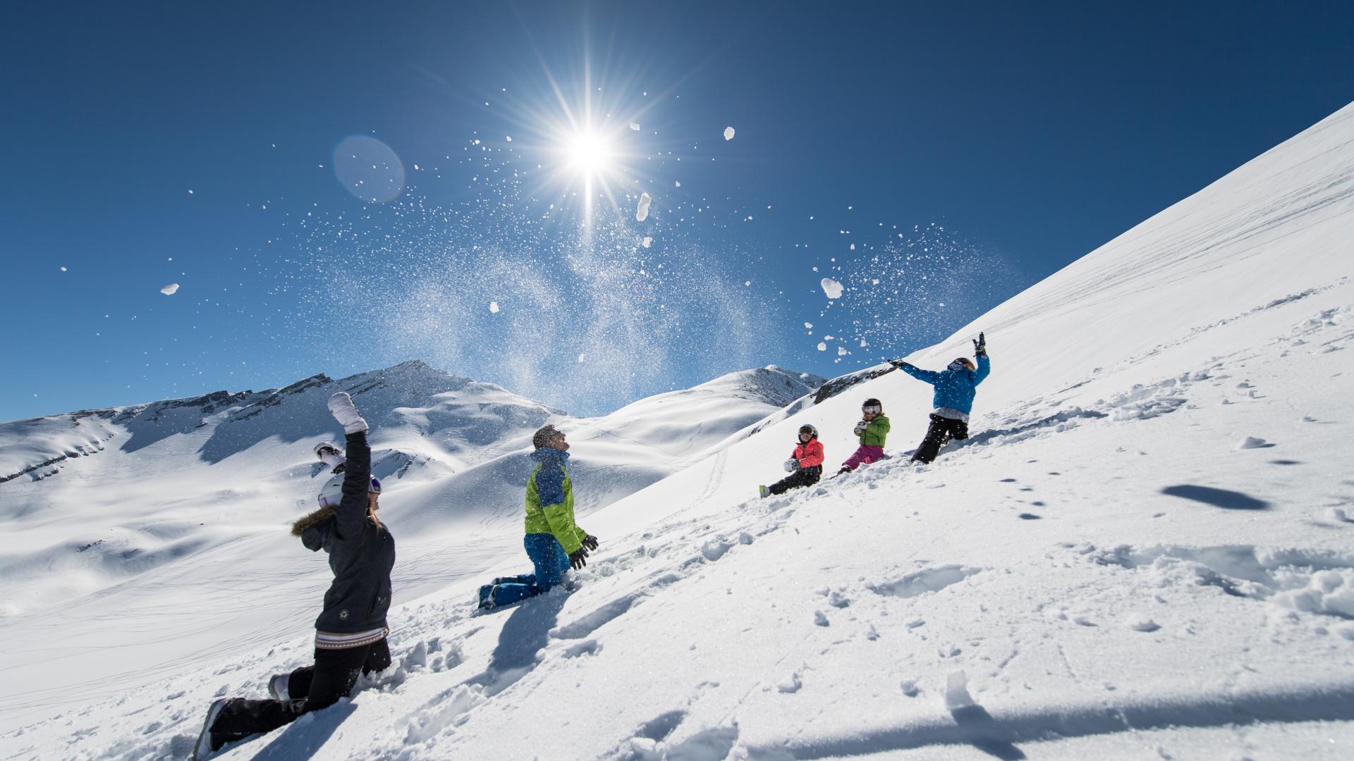 parents et enfants jouent dans la neige au ski aux Karellis